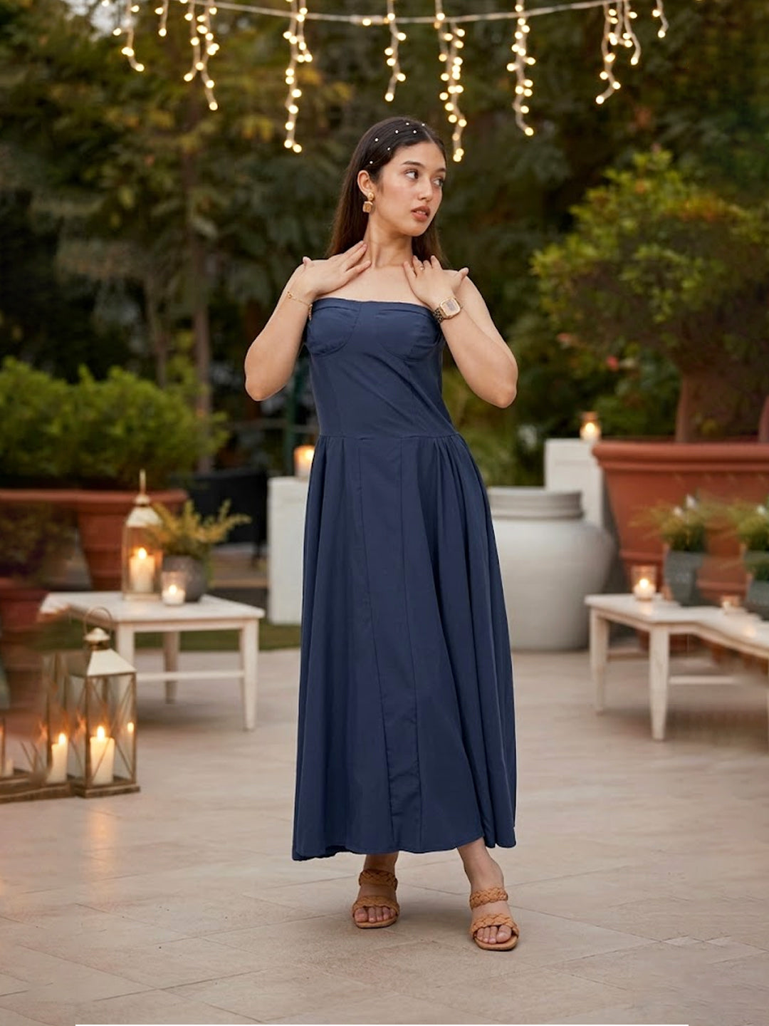 Woman in a blue dress standing on a patio