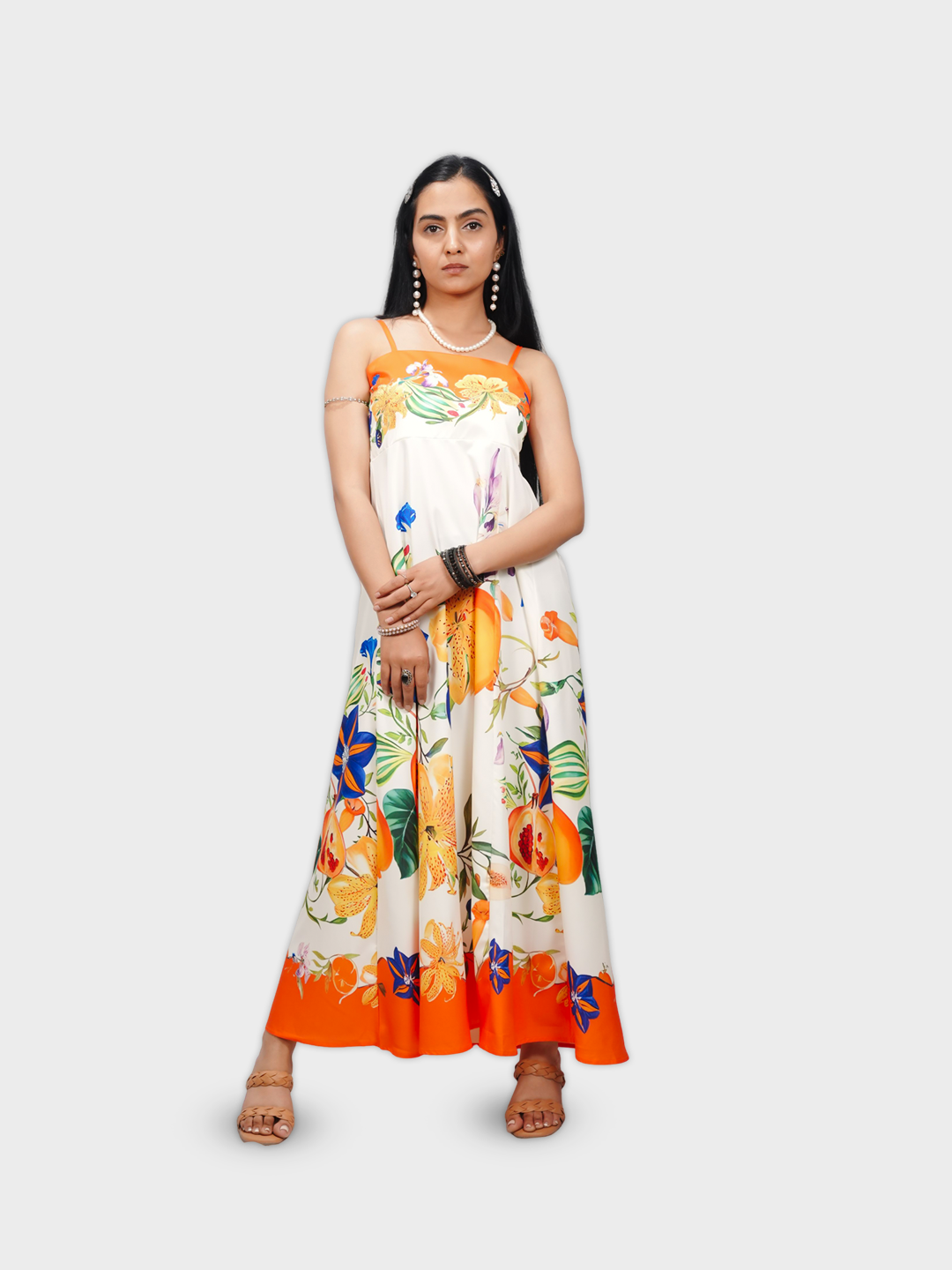 Woman wearing a floral dress with orange accents on a white background