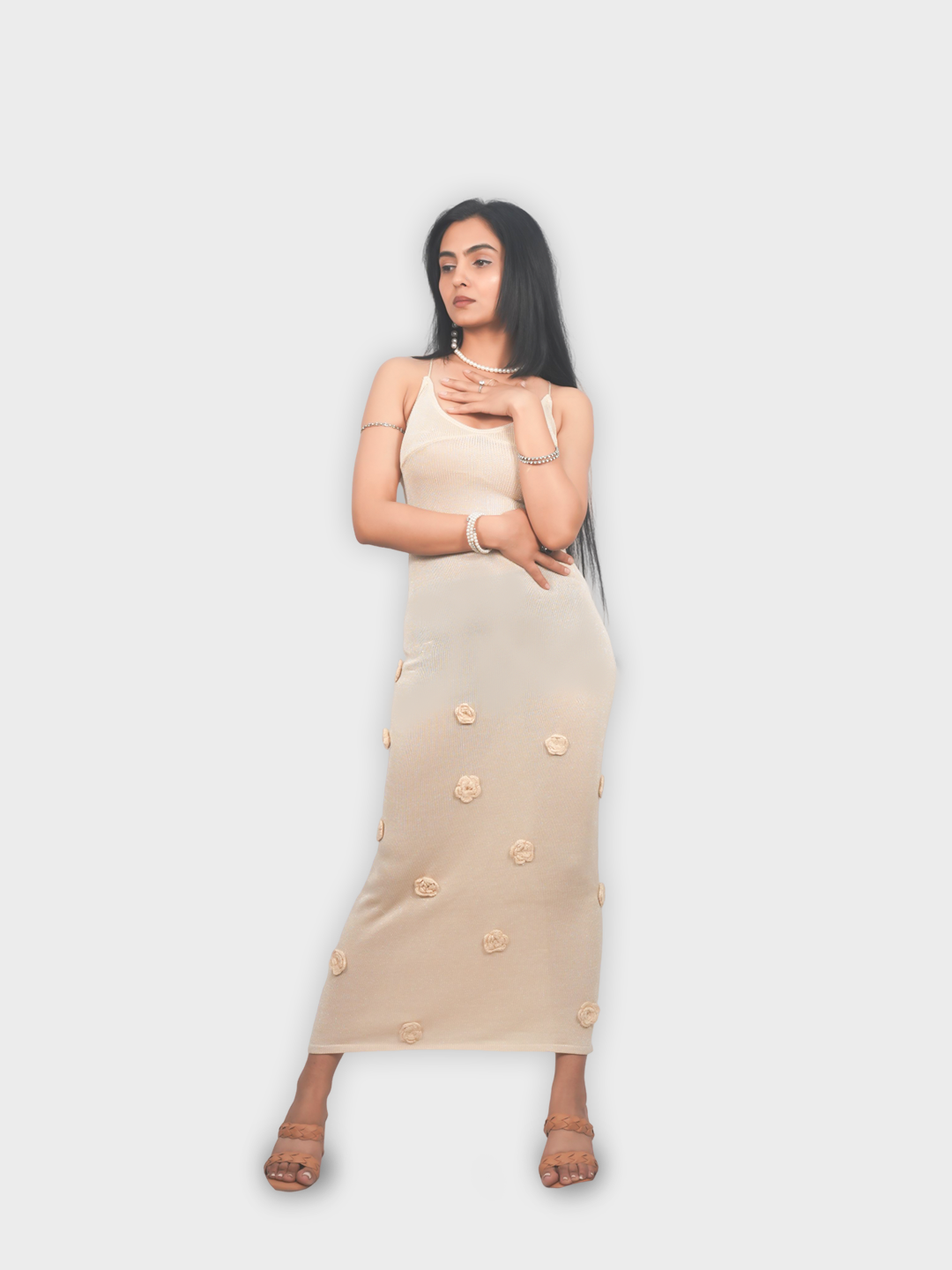 Woman wearing a beige dress with floral patterns on a white background
