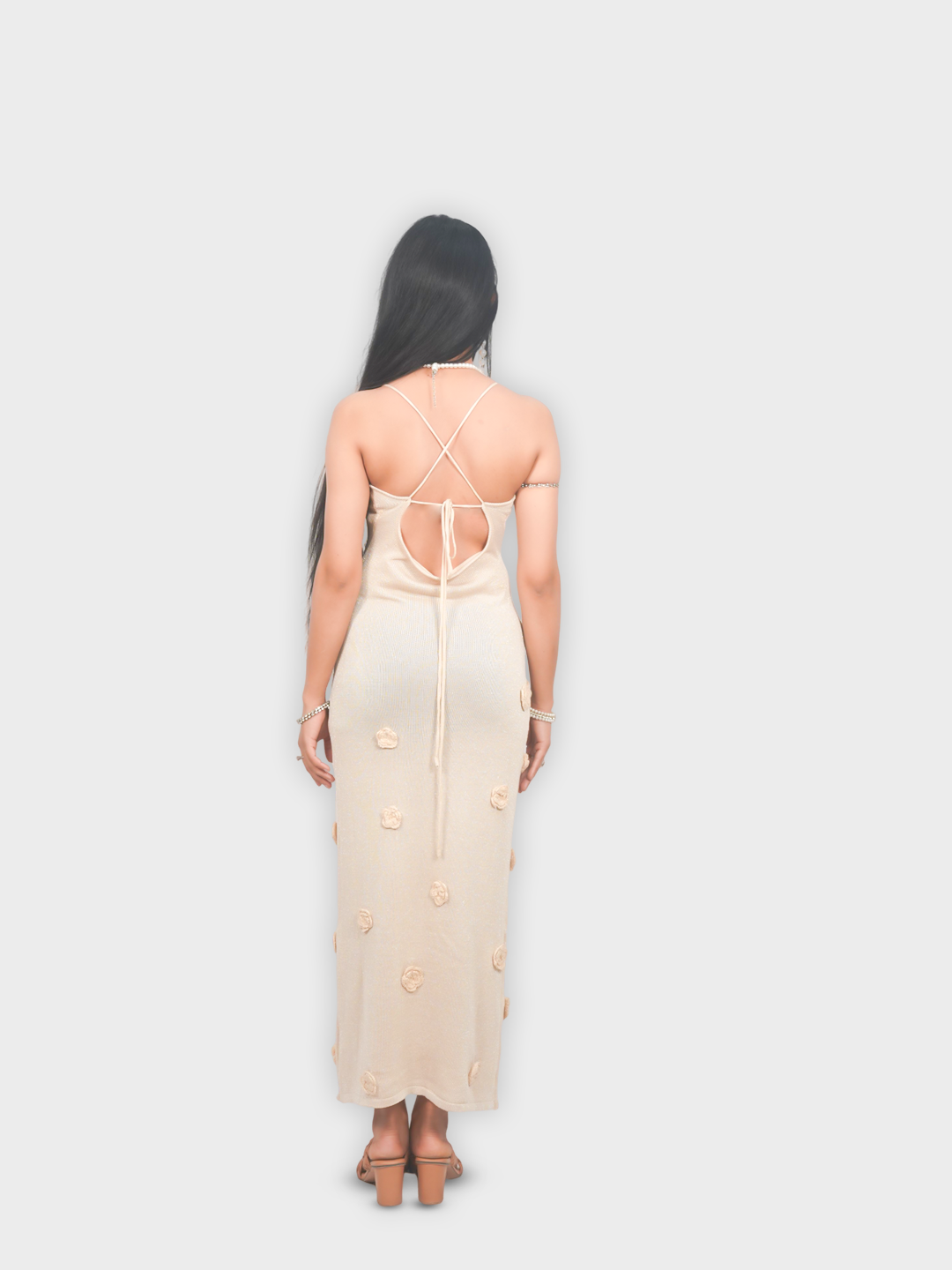 Woman wearing a long, light-colored dress with cut-out design 