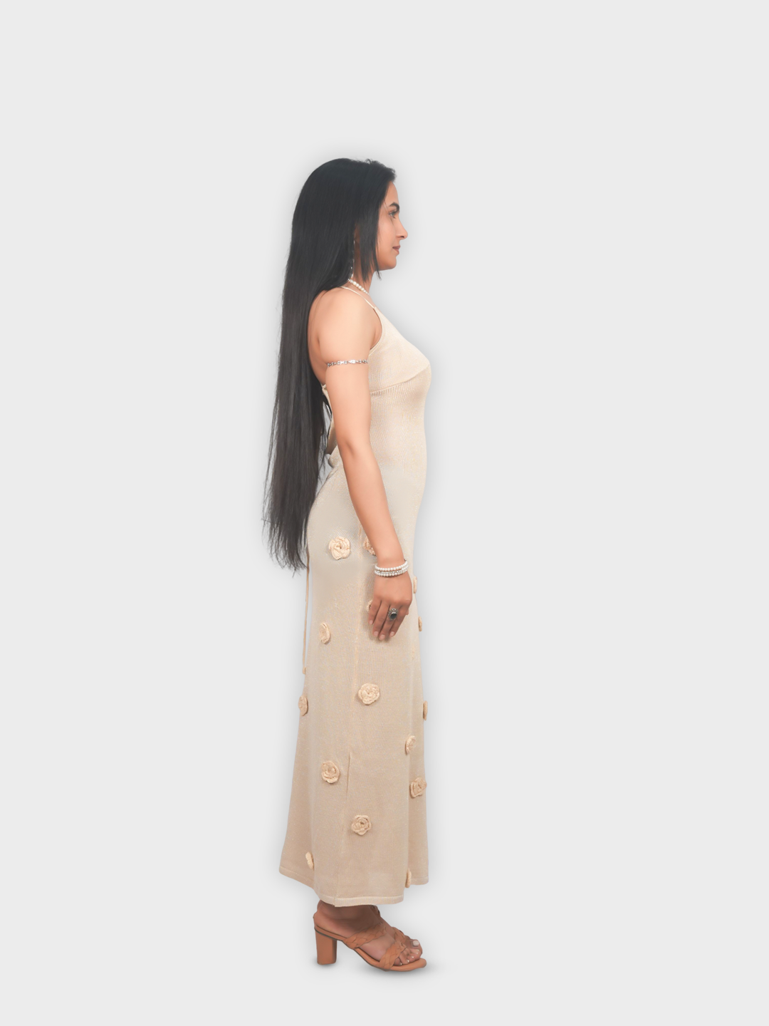 Woman wearing a beige dress with floral patterns on a white background
