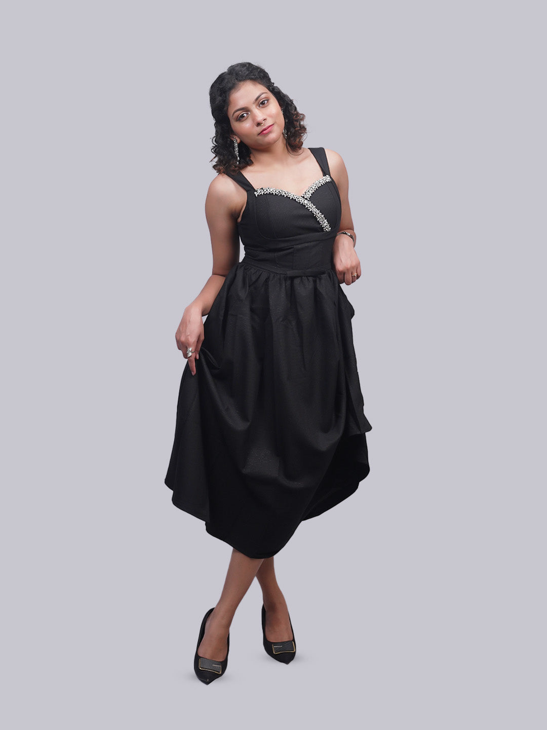 A woman modeling a black sleeveless midi dress.