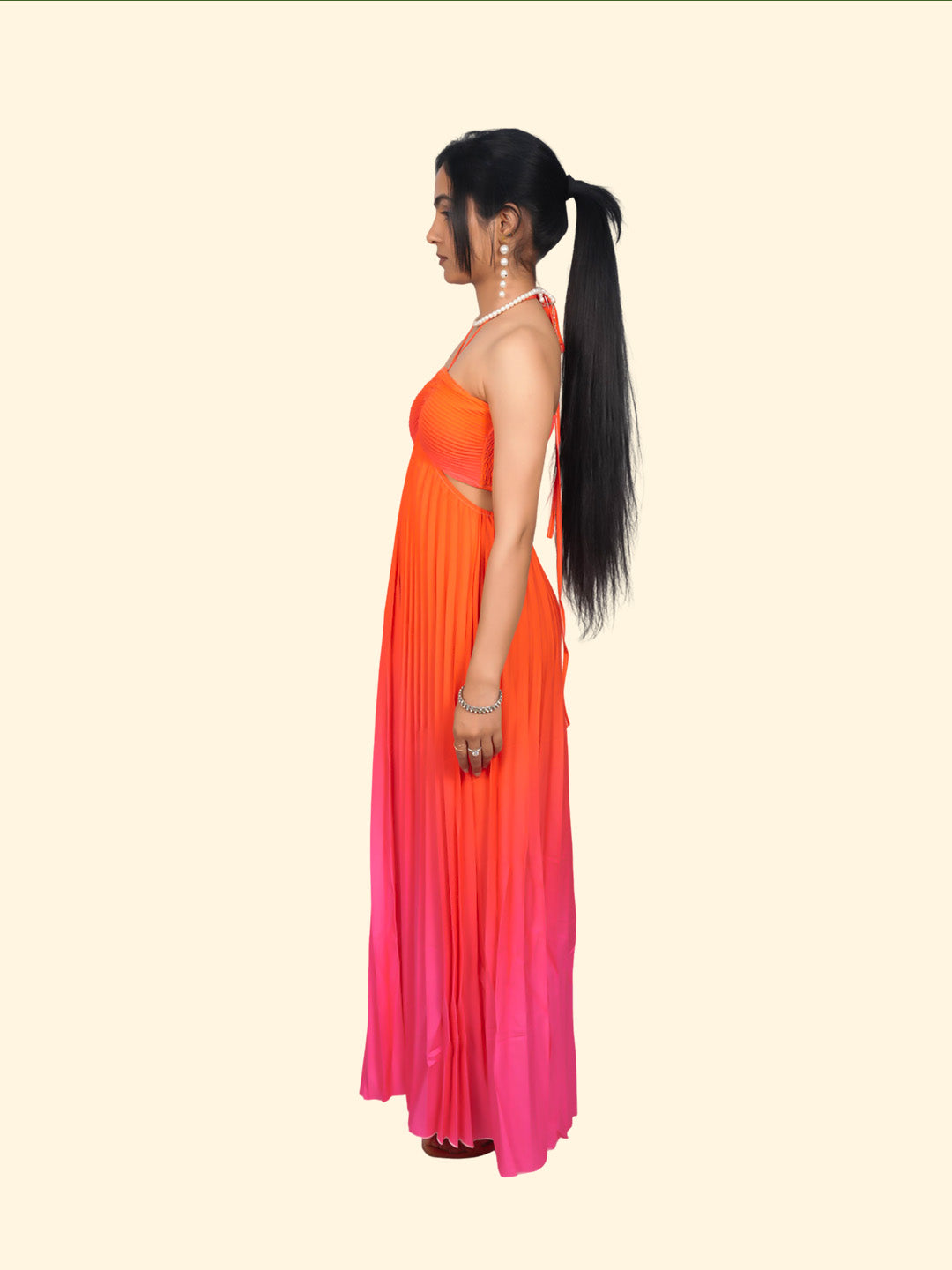 Woman wearing an orange to pink gradient dress on a beige background
