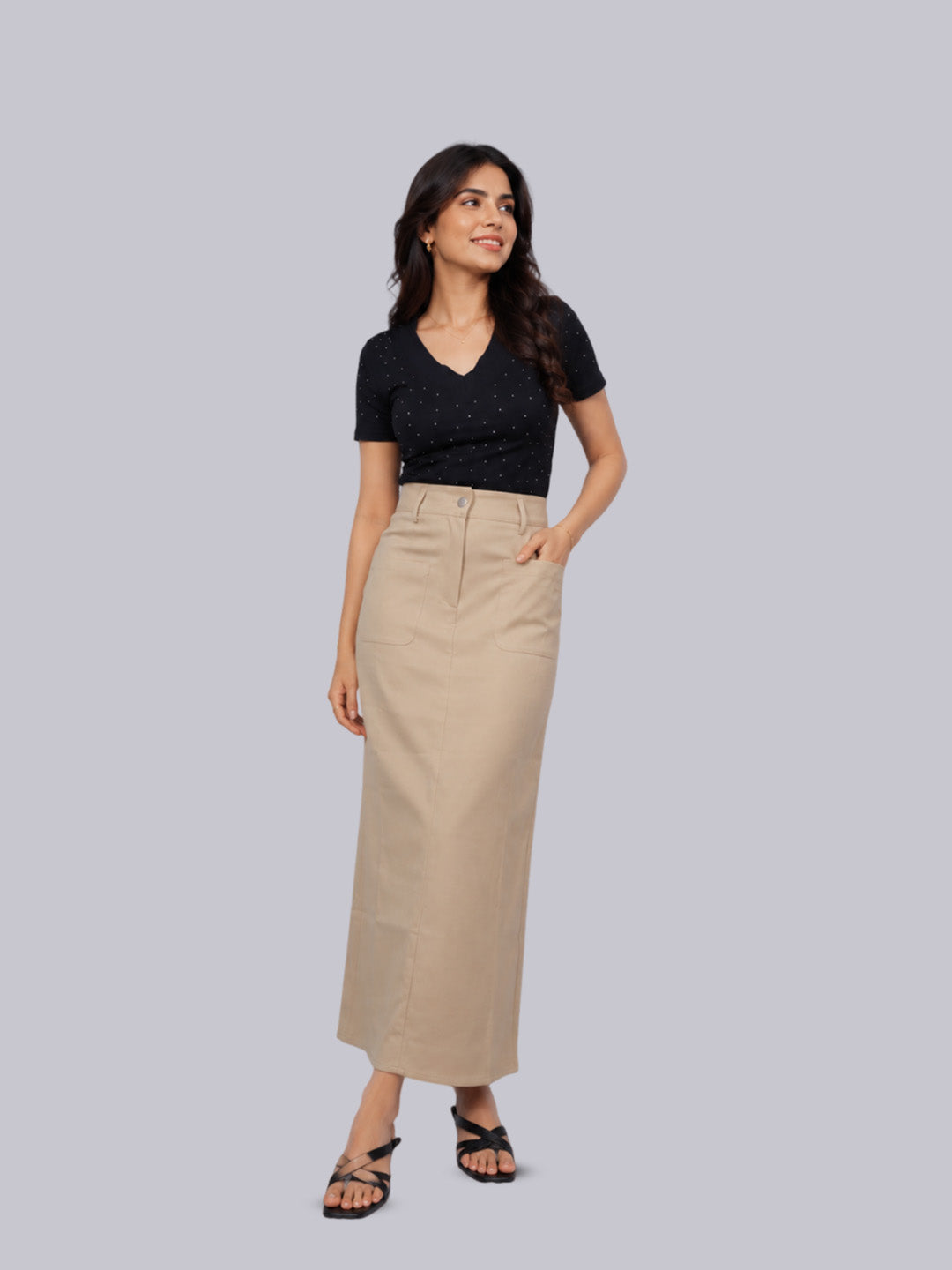 A woman modeling a black short-sleeve top and a high-waisted beige midi skirt