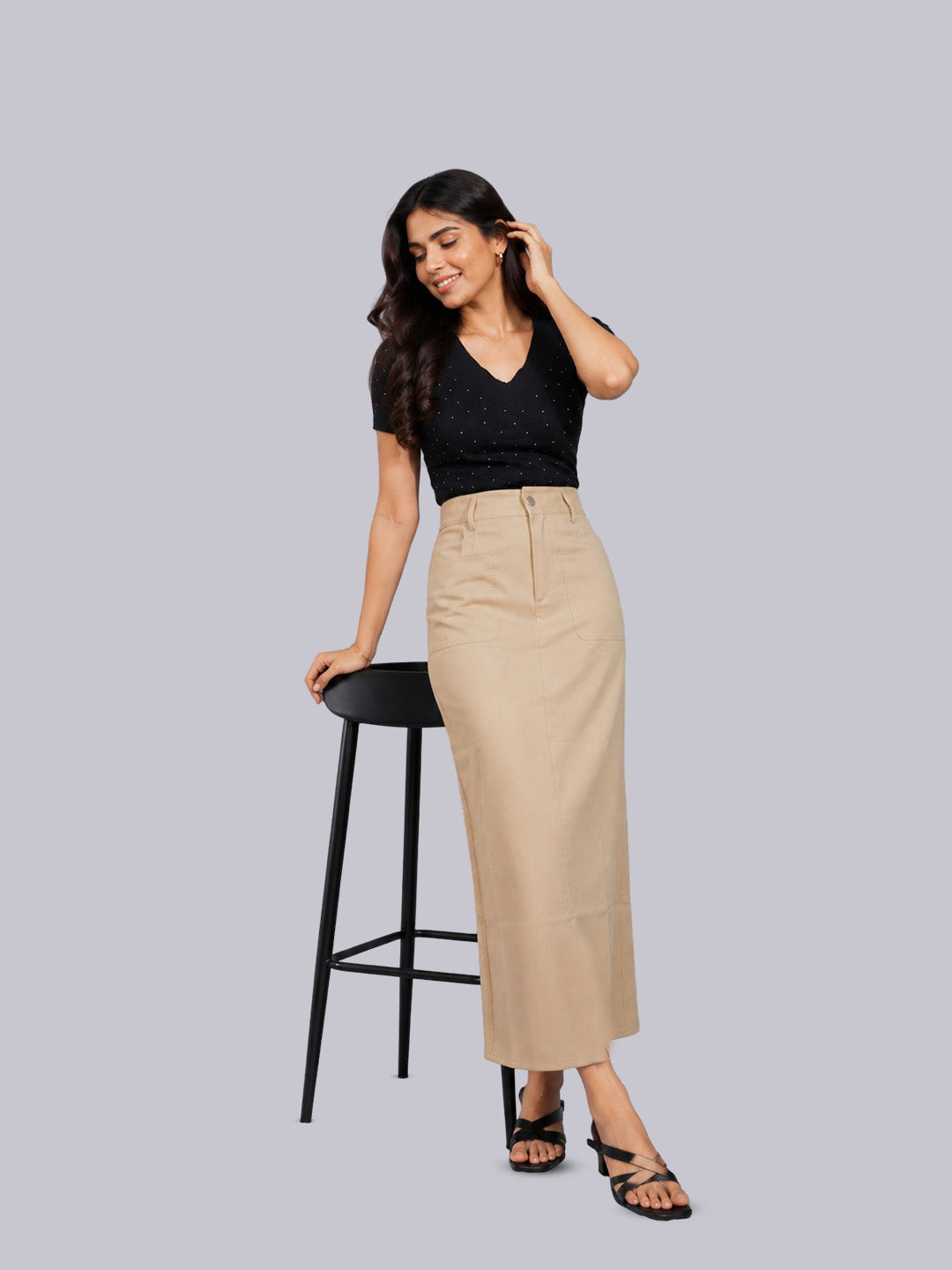 A black short-sleeve knit top and a beige high-waisted midi skirt