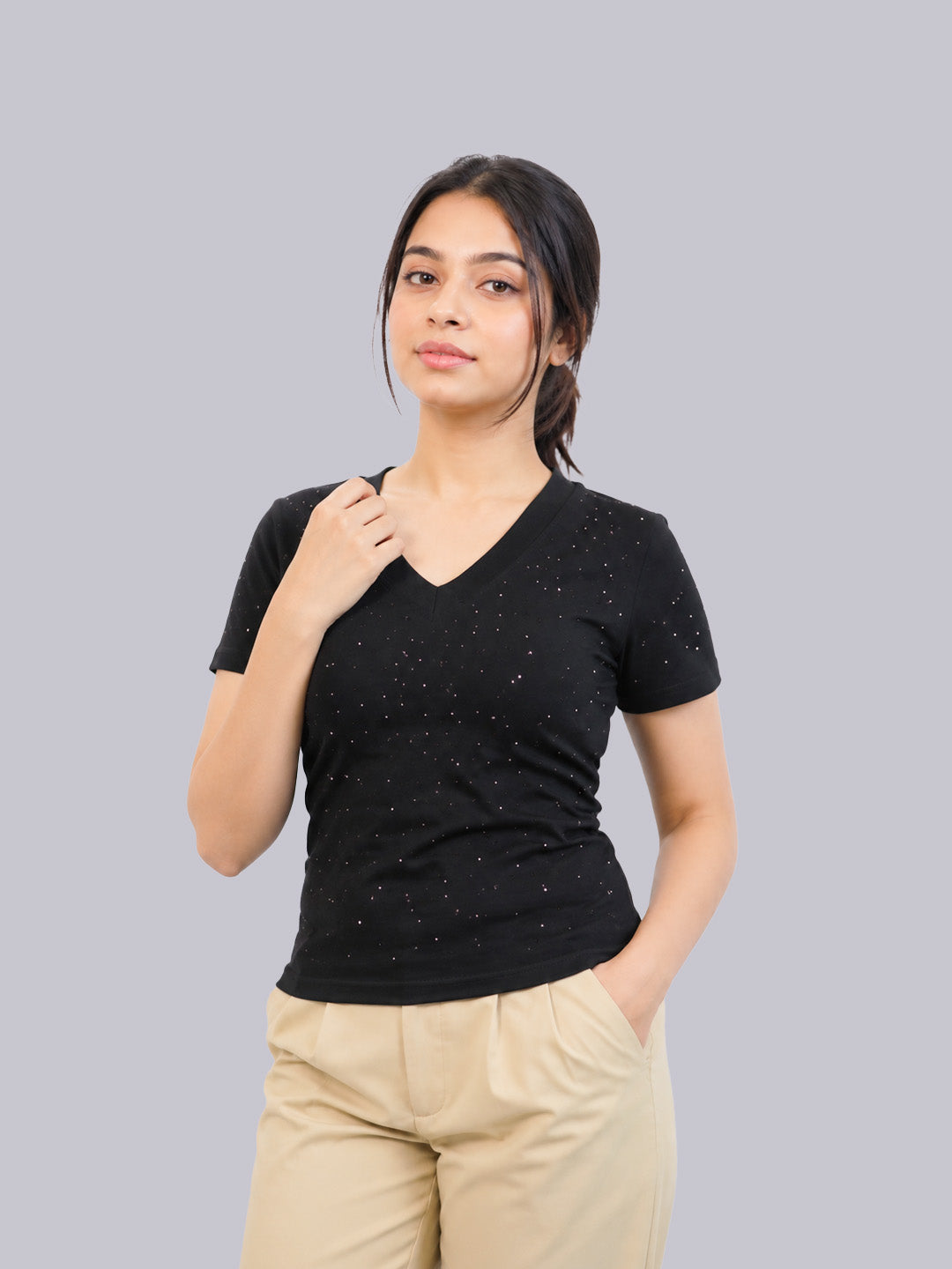 A woman modeling a black short-sleeve V-neck t-shirt with tiny white speckles.