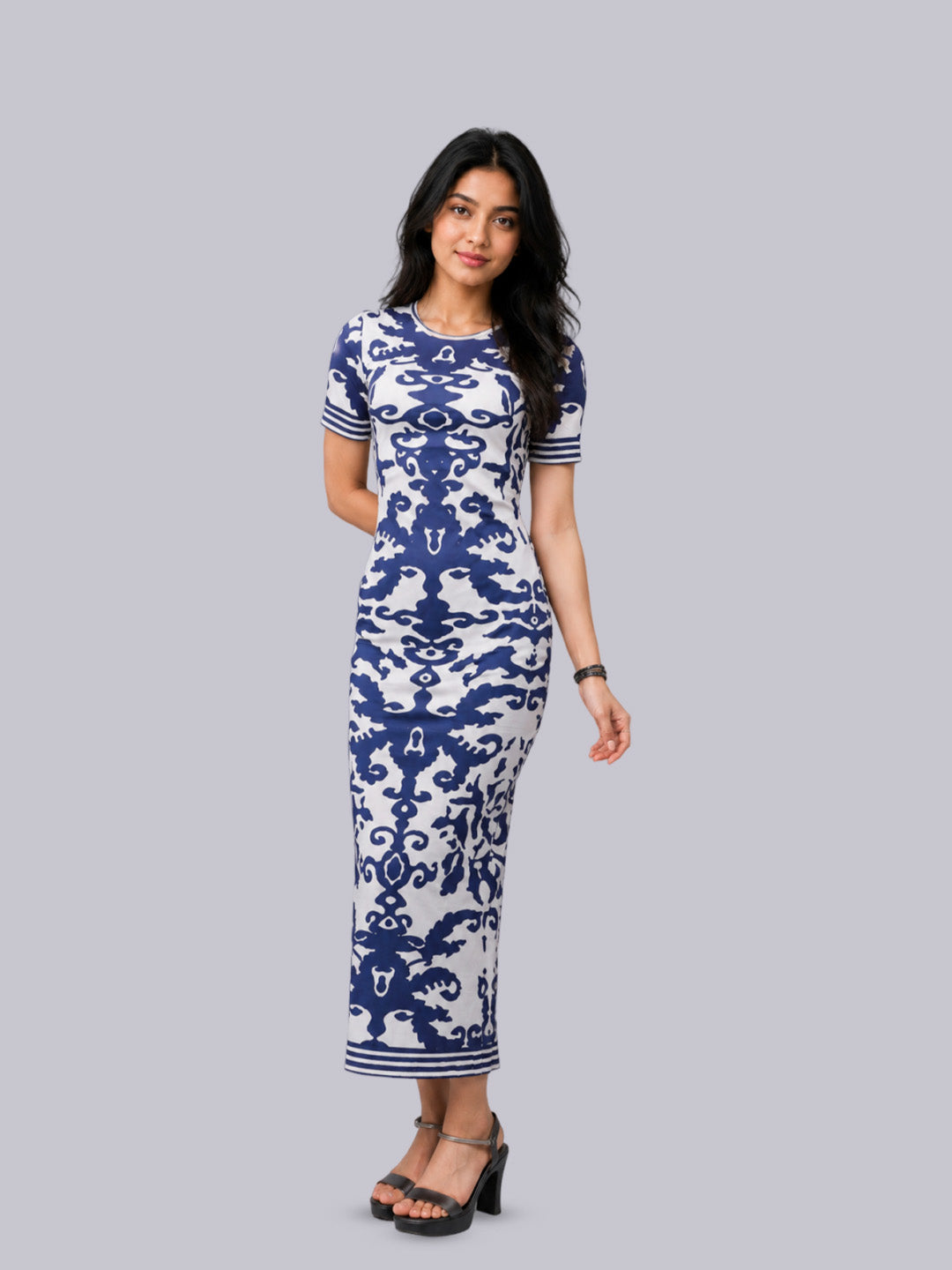 A woman modeling a short-sleeve, knee-length dress with a blue and white damask pattern.