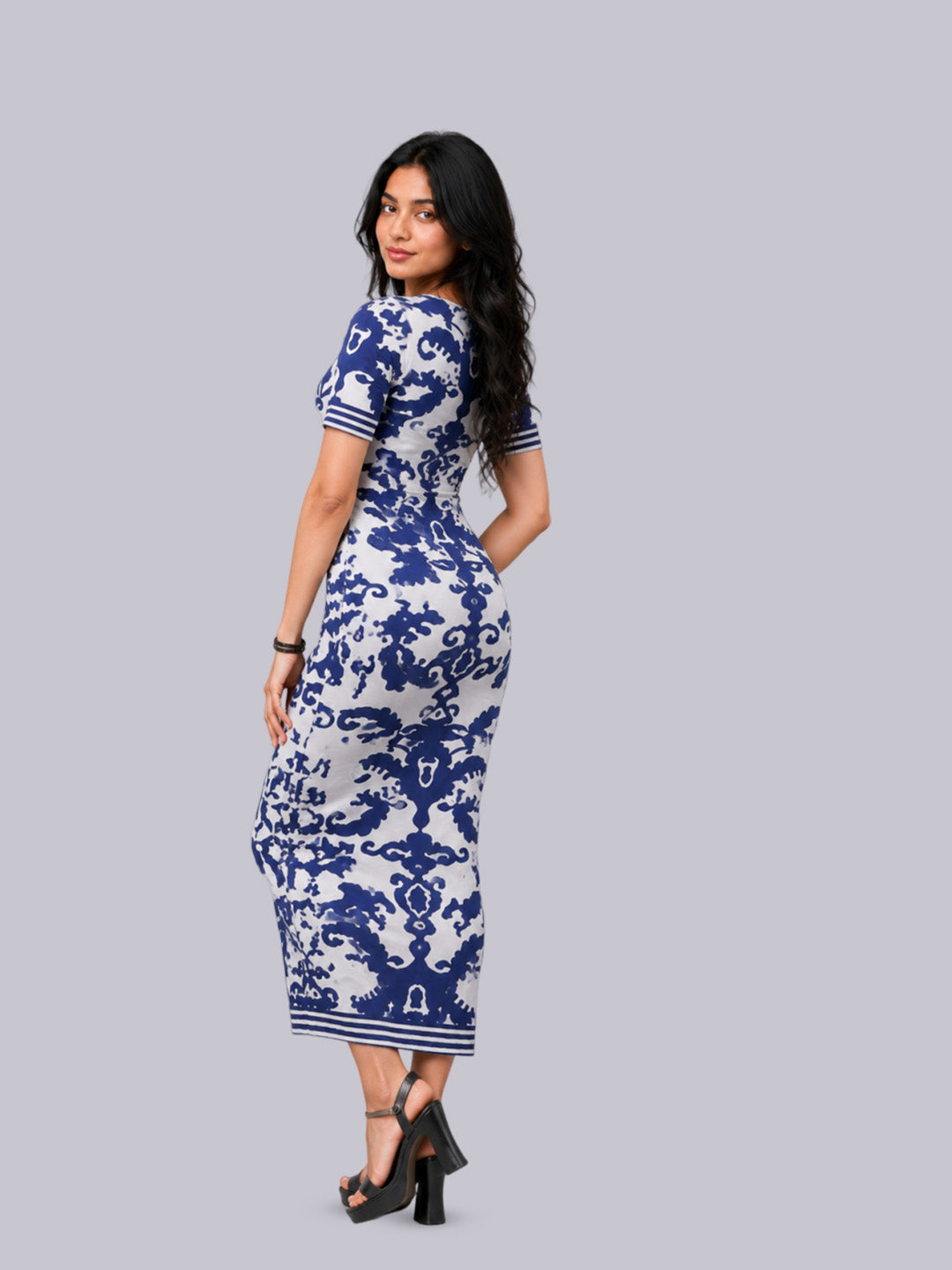A woman modeling a short-sleeve midi dress with a blue and white ornate pattern.