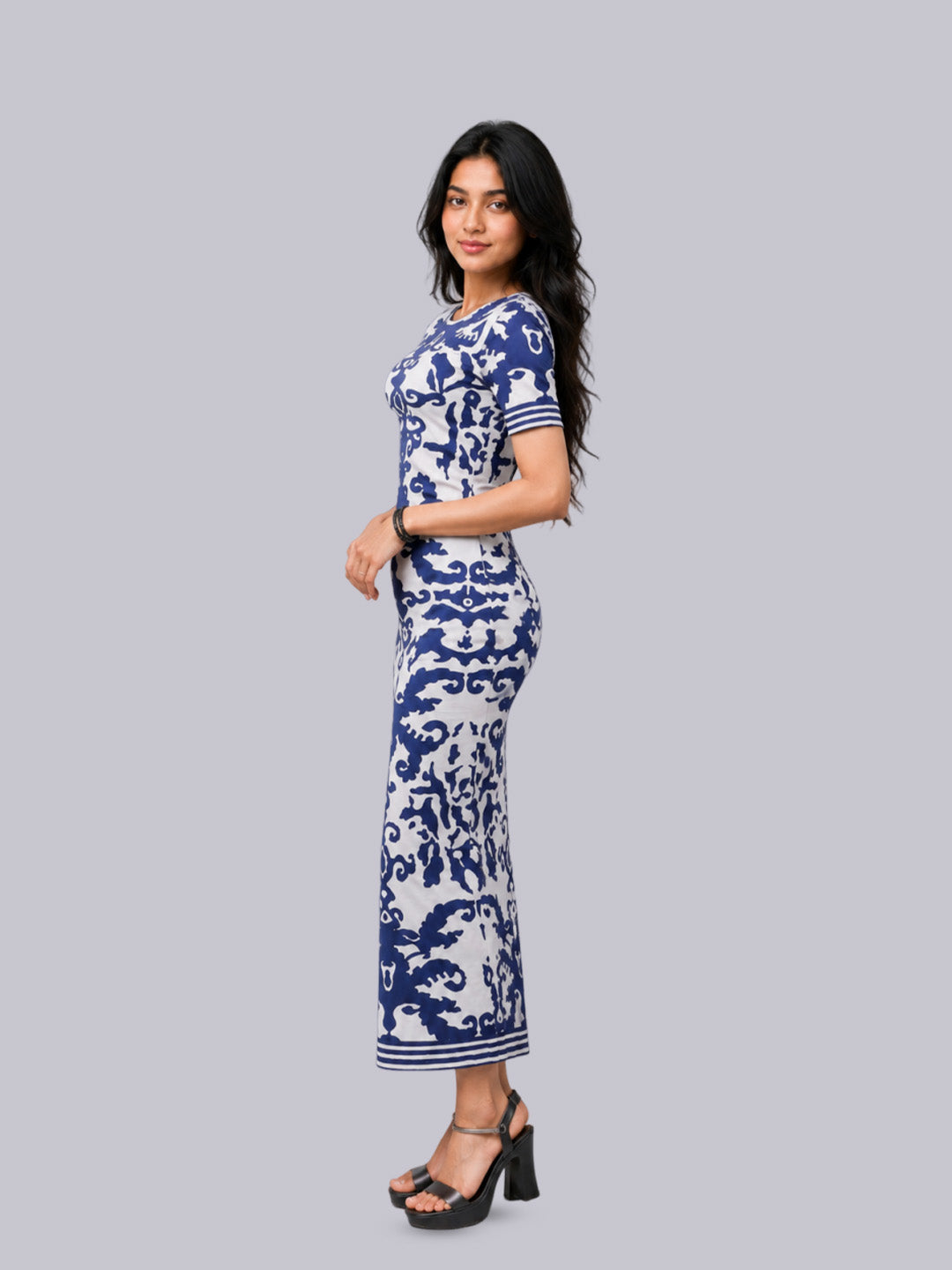A woman modeling a short-sleeve, knee-length dress with a blue and white baroque-style pattern.