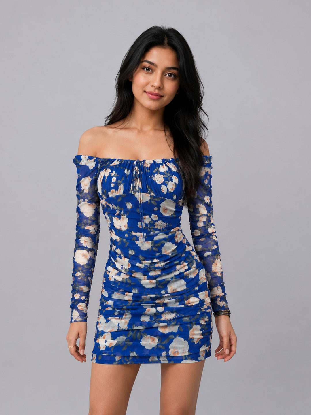A woman modeling an off-the-shoulder long-sleeve mini dress.