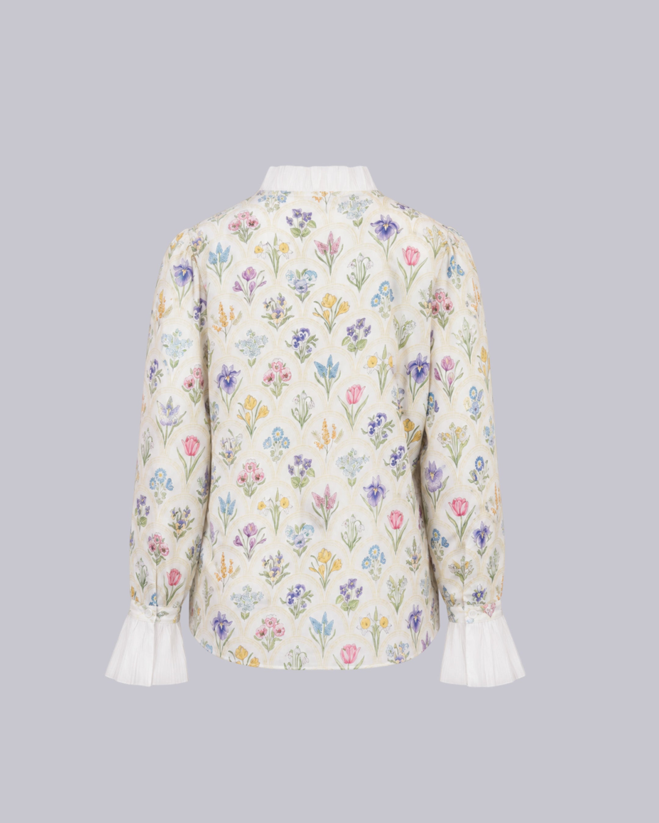 A long-sleeve blouse shown from the back, featuring an all-over delicate floral print on a cream base