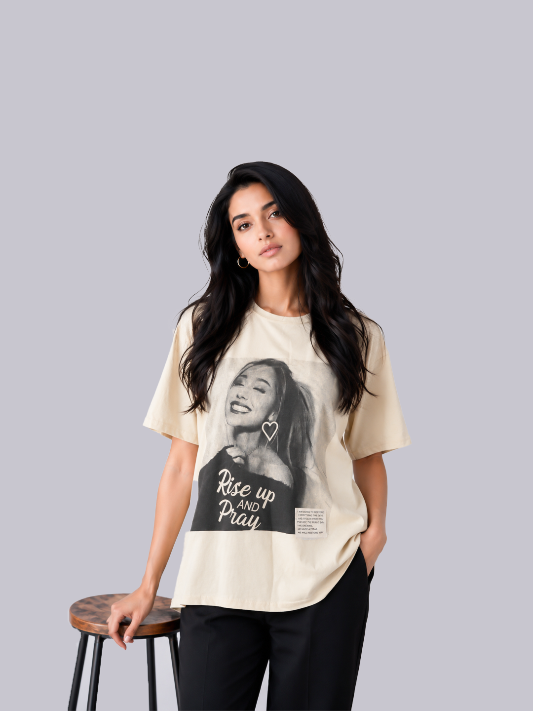 A woman modeling a cream-colored graphic t-shirt with a black-and-white portrait.