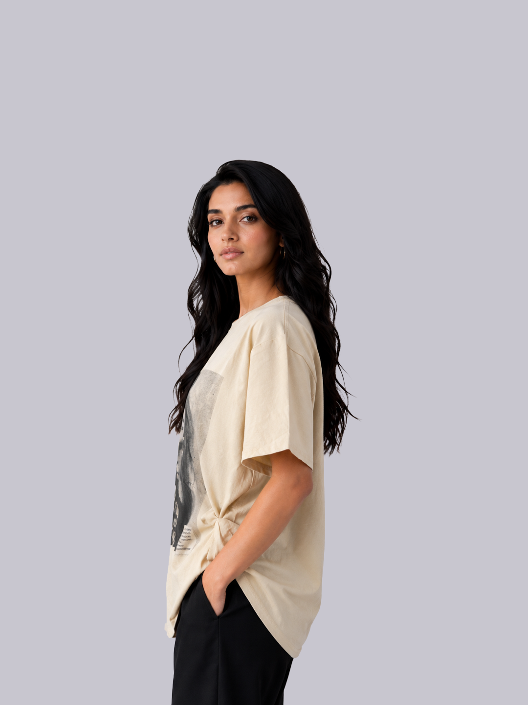 A woman with long, wavy black hair is shown in profile wearing a cream-colored oversized t-shirt .