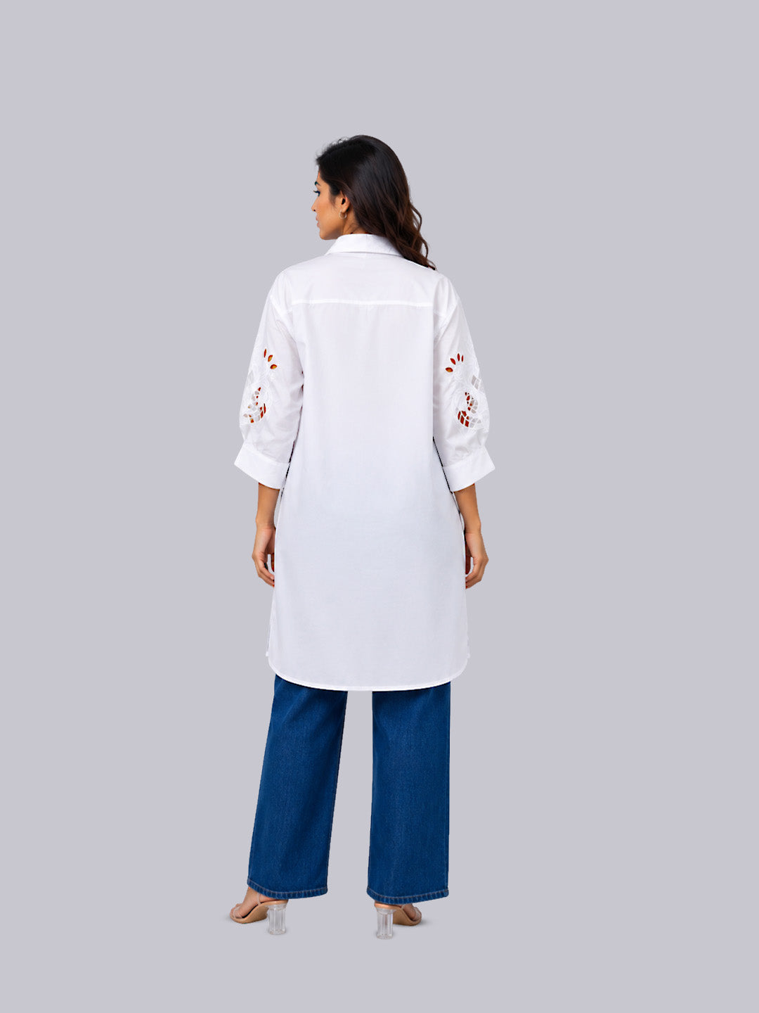 A white long-sleeve tunic with red floral embroidery on the sleeves, paired