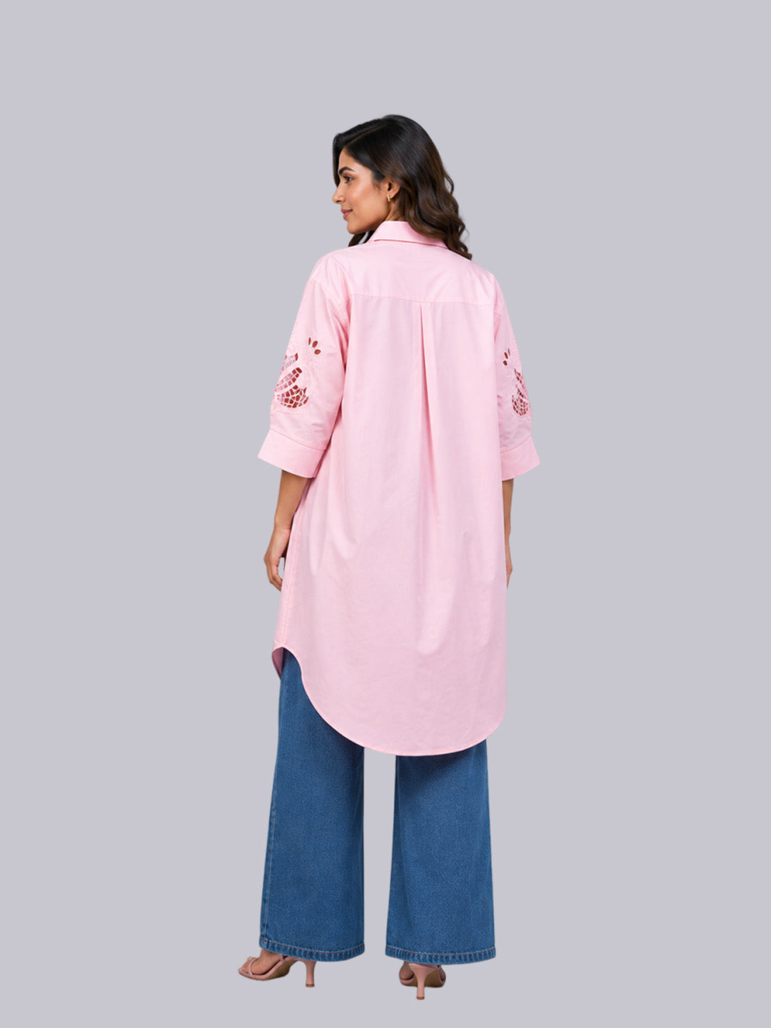 A the back wearing a light pink long kurta with floral embroidery