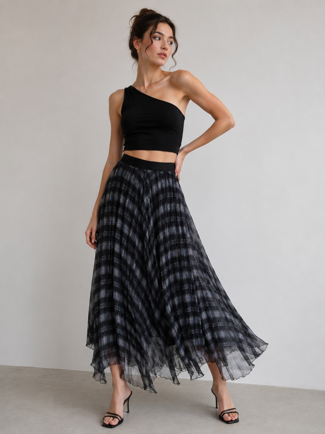 A woman modeling a black one-shoulder crop top 