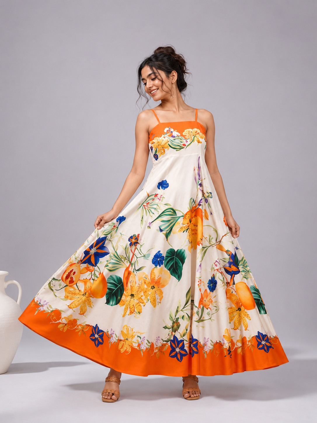 A sleeveless maxi dress with a white base and a vibrant orange, yellow, and blue floral print