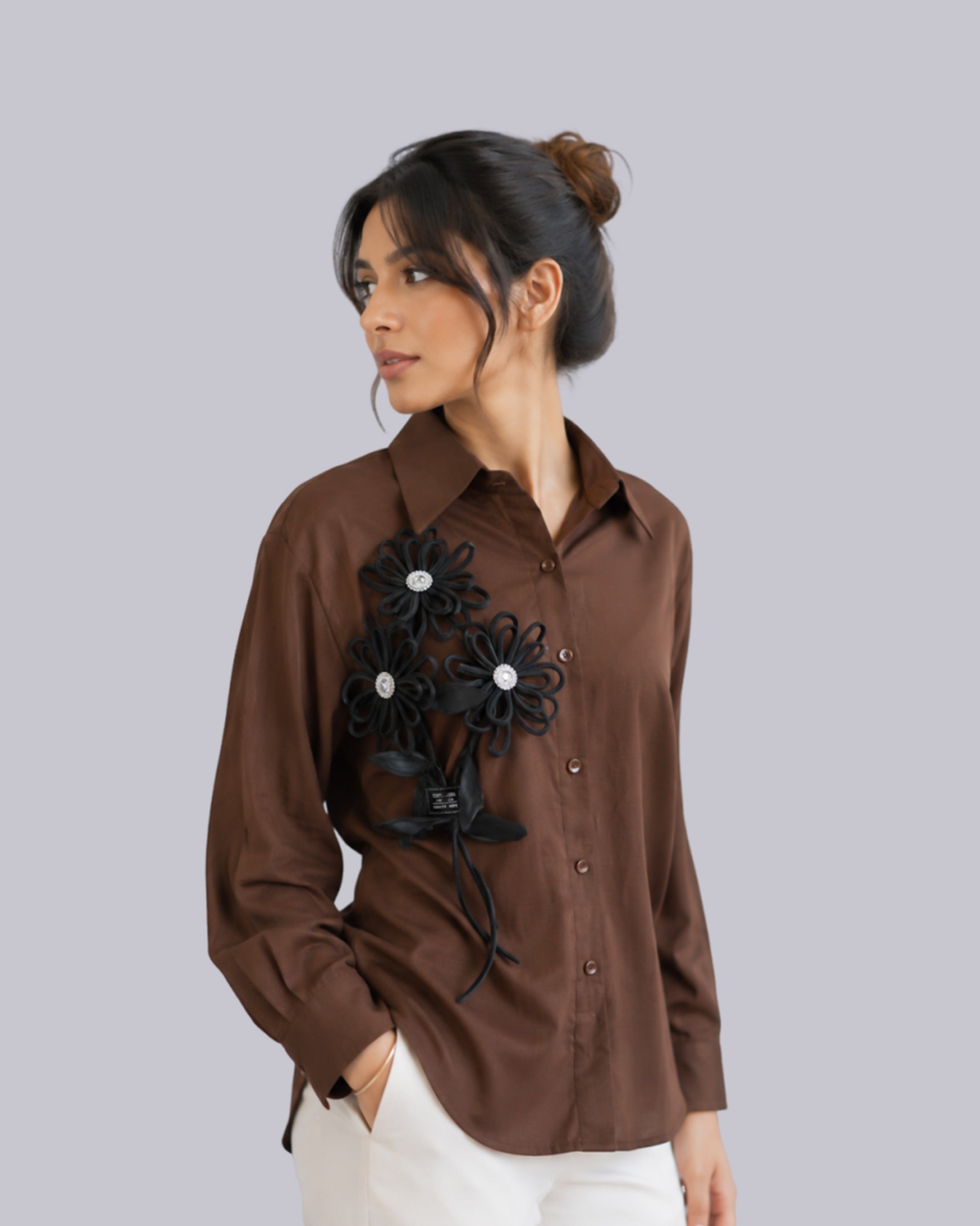 A woman wearing a brown button-up shirt 