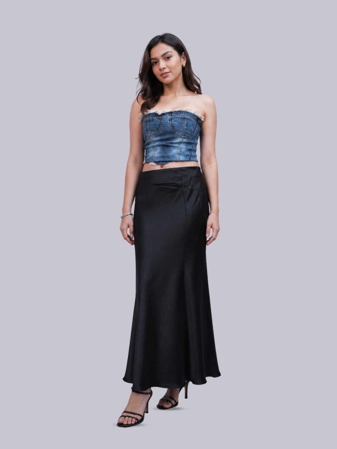 A long black satin skirt, set against