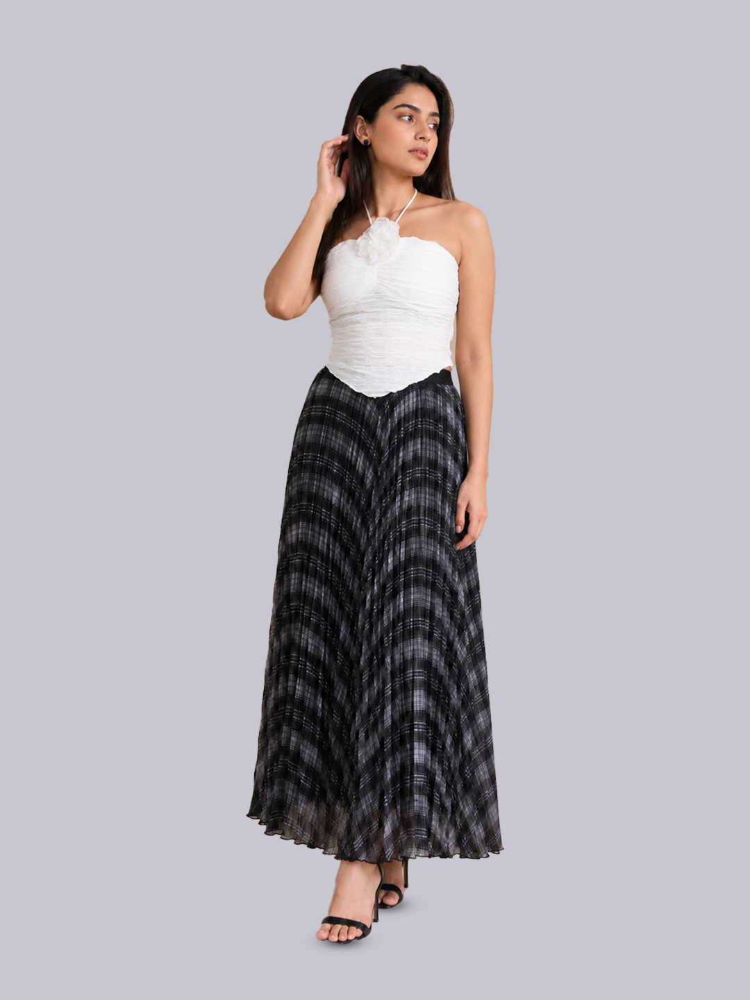 A woman modeling a two-piece outfit consisting of a white halter-neck crop top.