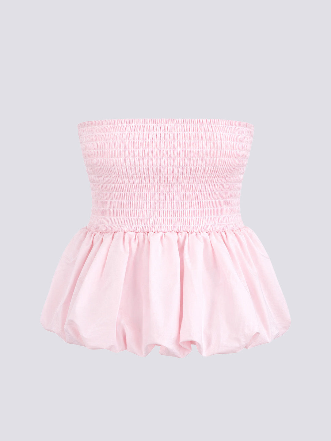 A light pink strapless top with a smocked bodice and a ruffled peplum hem.
