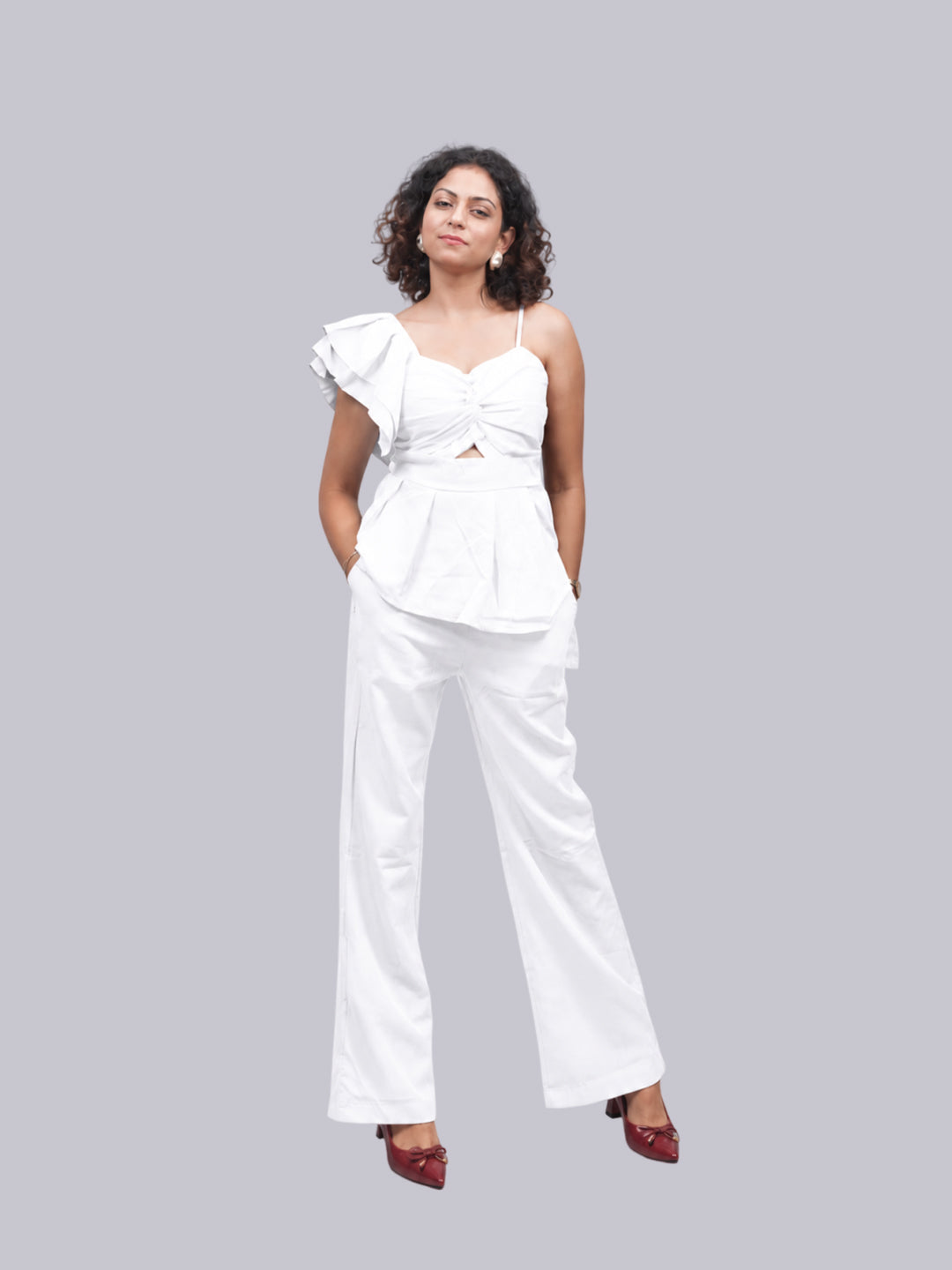 A white two-piece outfit consisting of a one-shoulder ruffled top