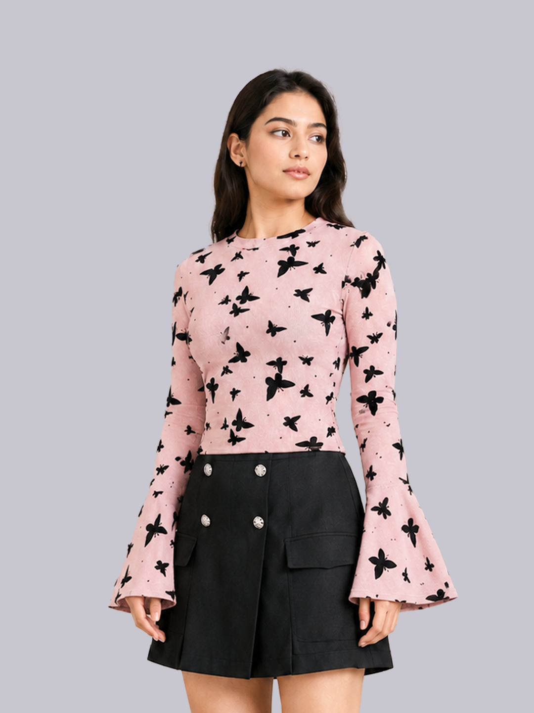 A woman modeling a pink long-sleeve top with a black butterfly print.