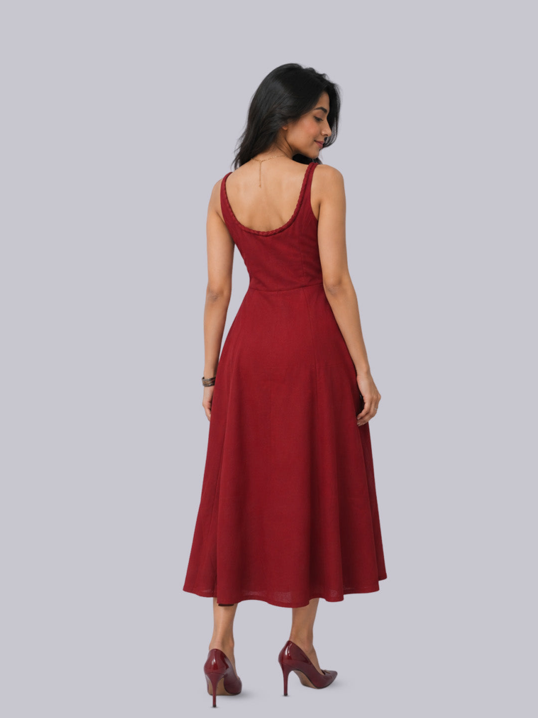 The back wearing a sleeveless, midi-length red dress. 