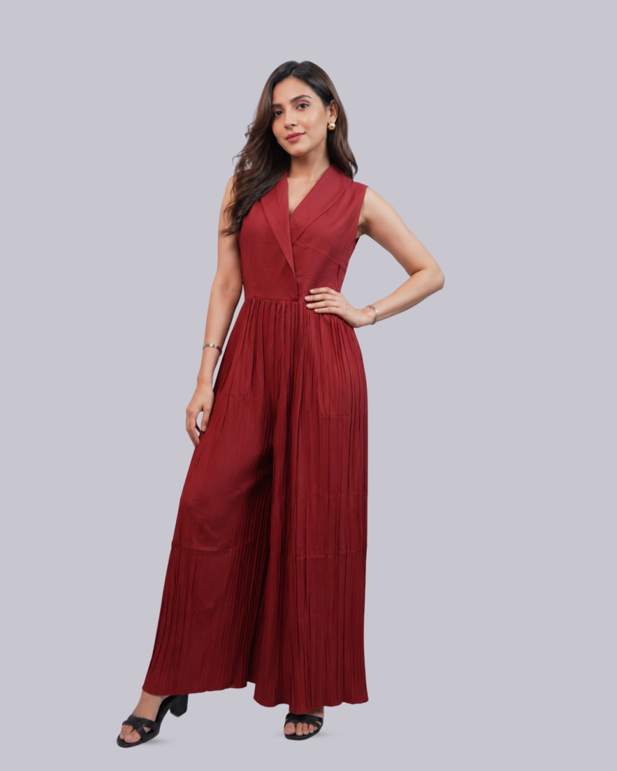 A sleeveless, deep red pleated jumpsuit.