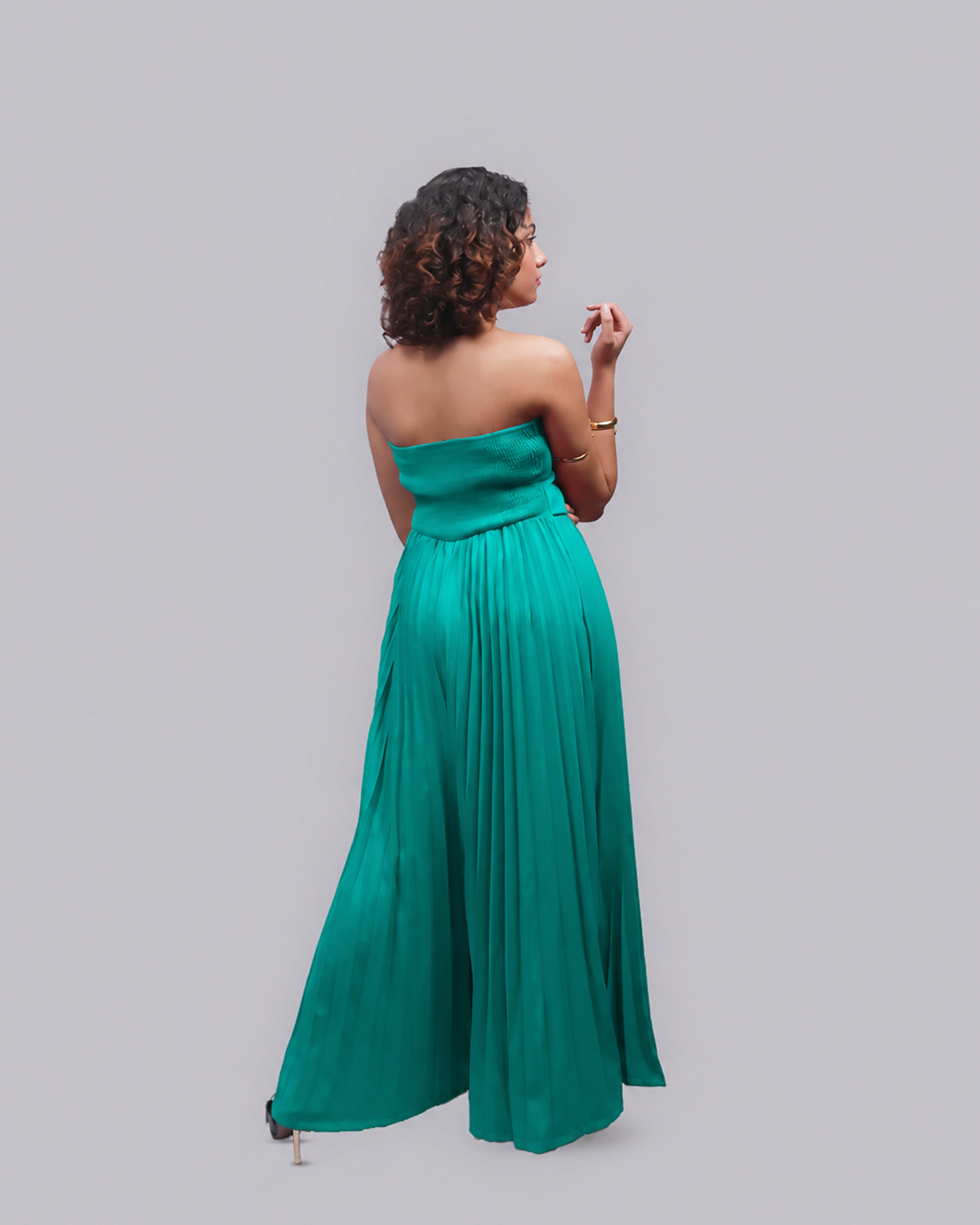 A woman wearing a strapless emerald green maxi dress