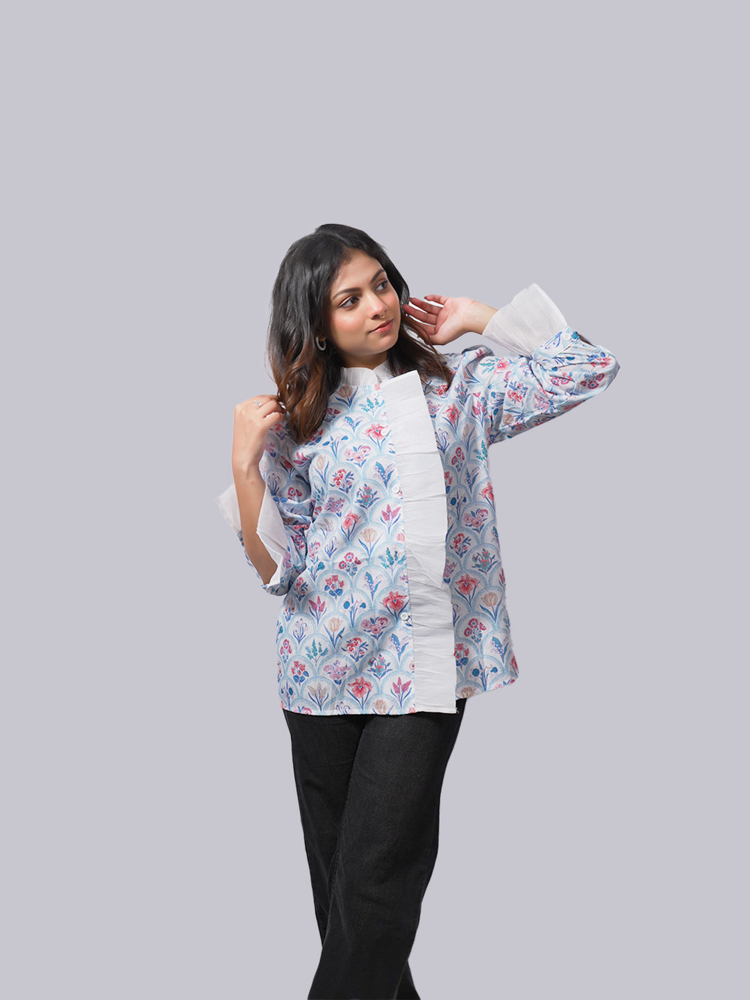 A woman modeling a white long-sleeve kurta with a blue and pink floral print.