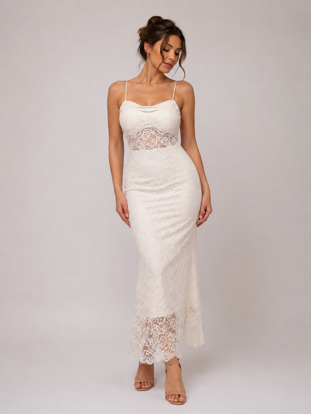 A woman modeling a white lace spaghetti-strap maxi dress