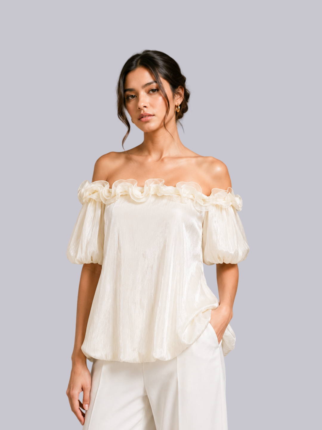 A woman modeling an off-the-shoulder cream-colored blouse.