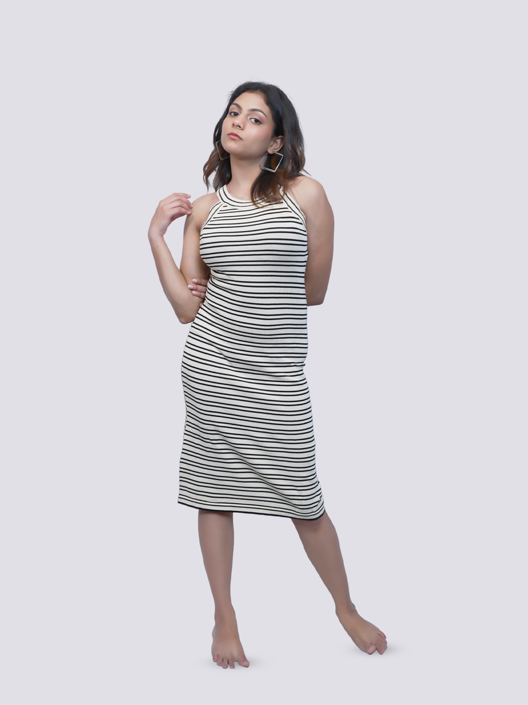A woman modeling a sleeveless, high-neck, knee-length dress.