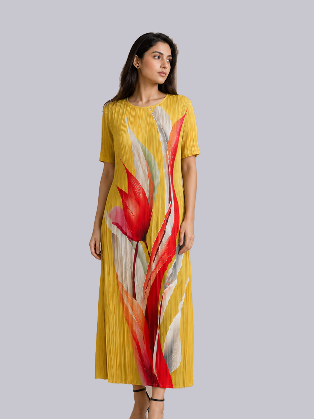 A woman modeling a yellow pleated midi dress with a large abstract red, white, and orange floral print.