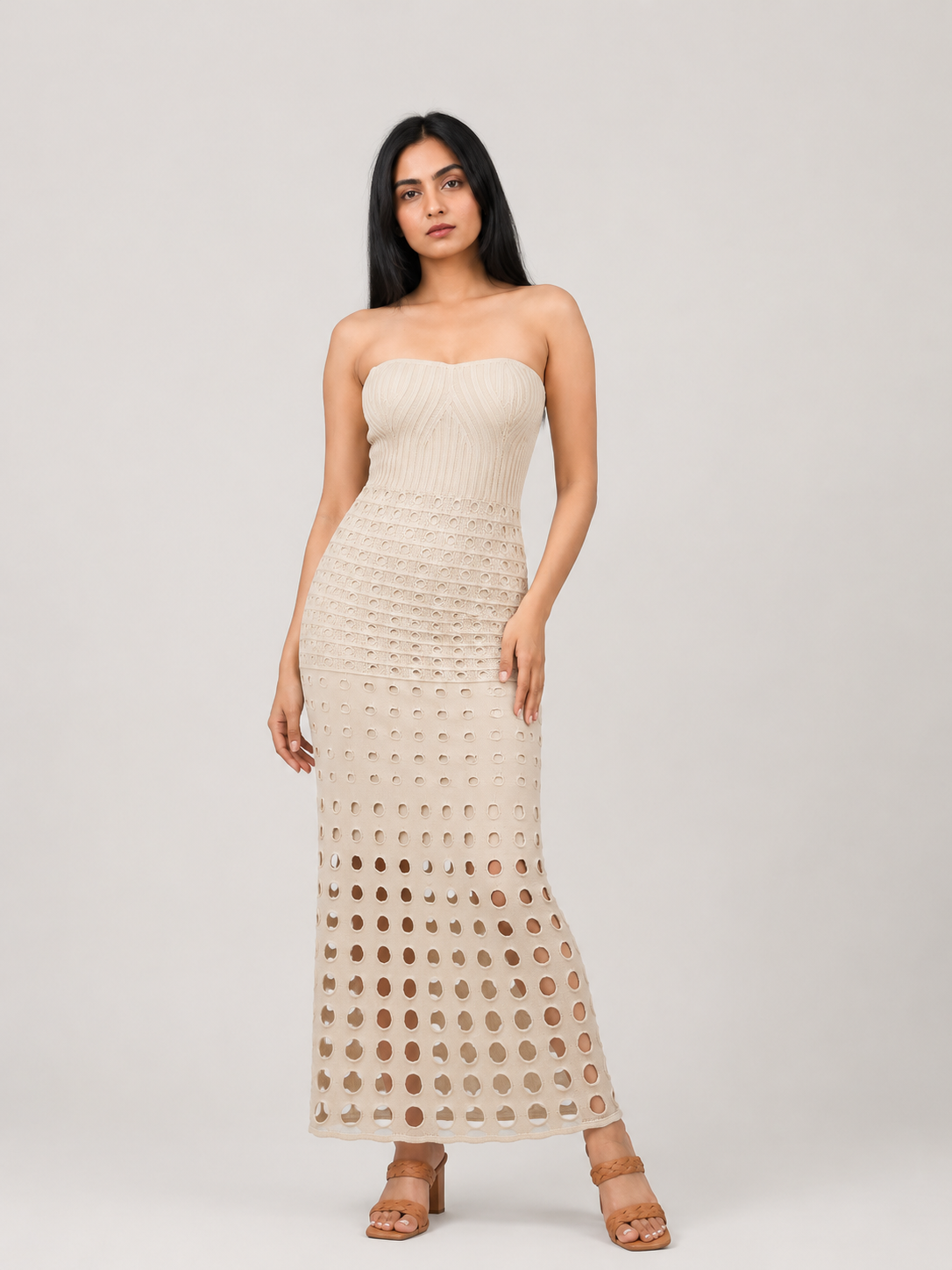 A strapless knit maxi dress in a warm cream or off-white color, featuring a textured