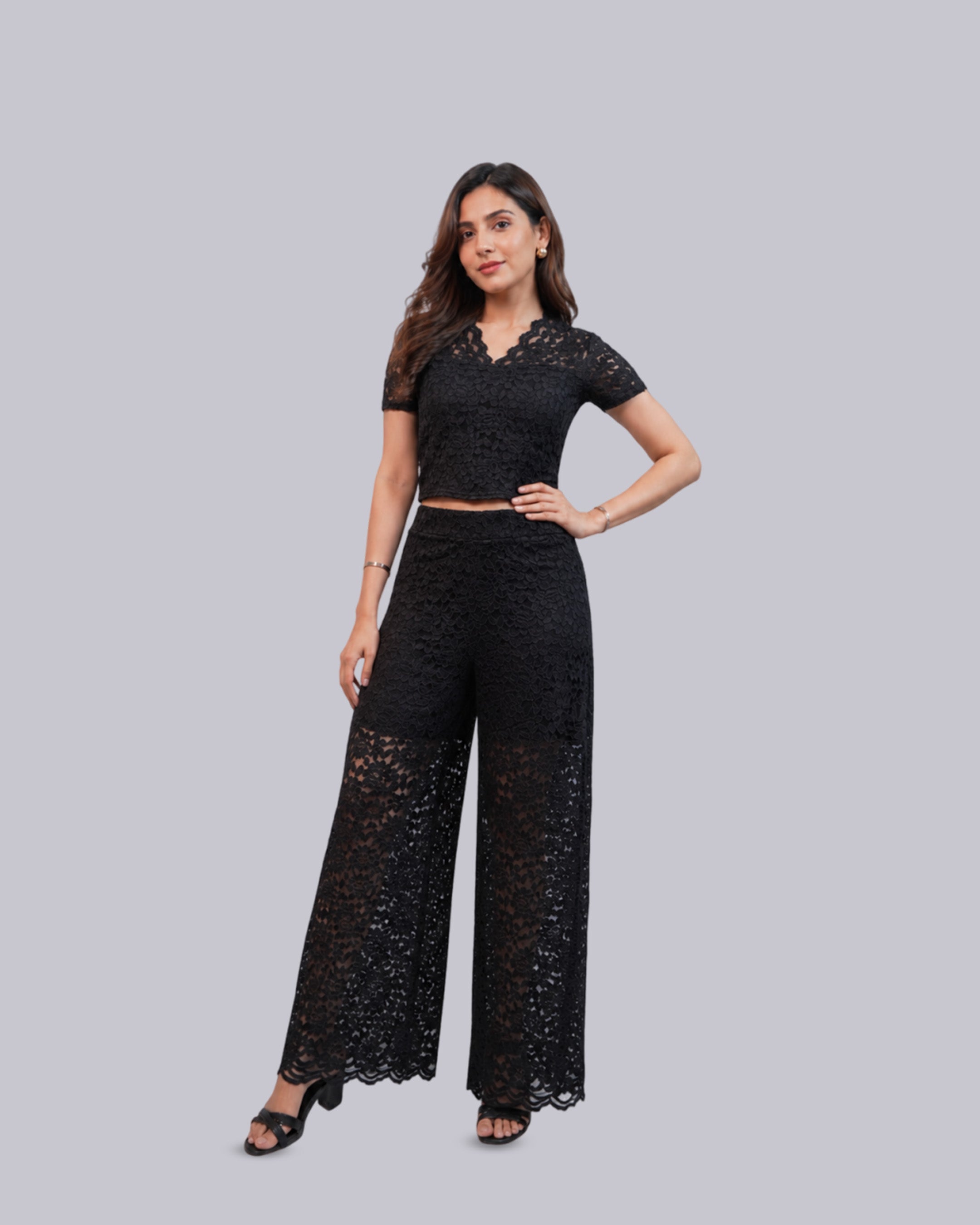 A woman modeling a black lace two-piece set consisting of a short-sleeve.