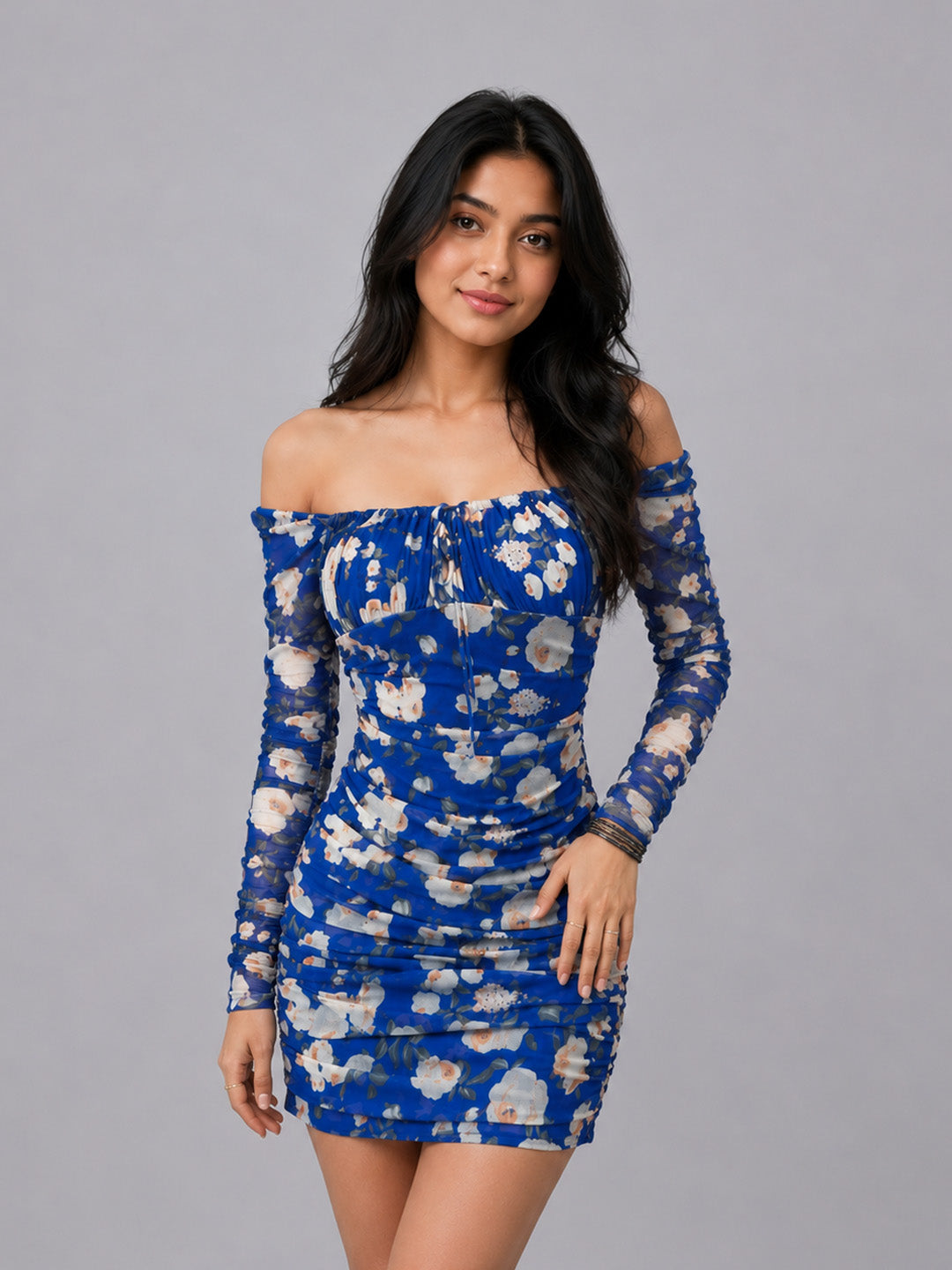 A woman modeling an off-the-shoulder long-sleeve mini dress.