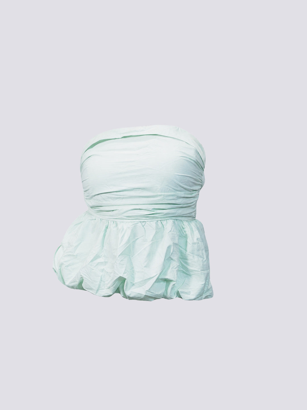A strapless ruffled top in a pale mint green color, shown against a solid light gray