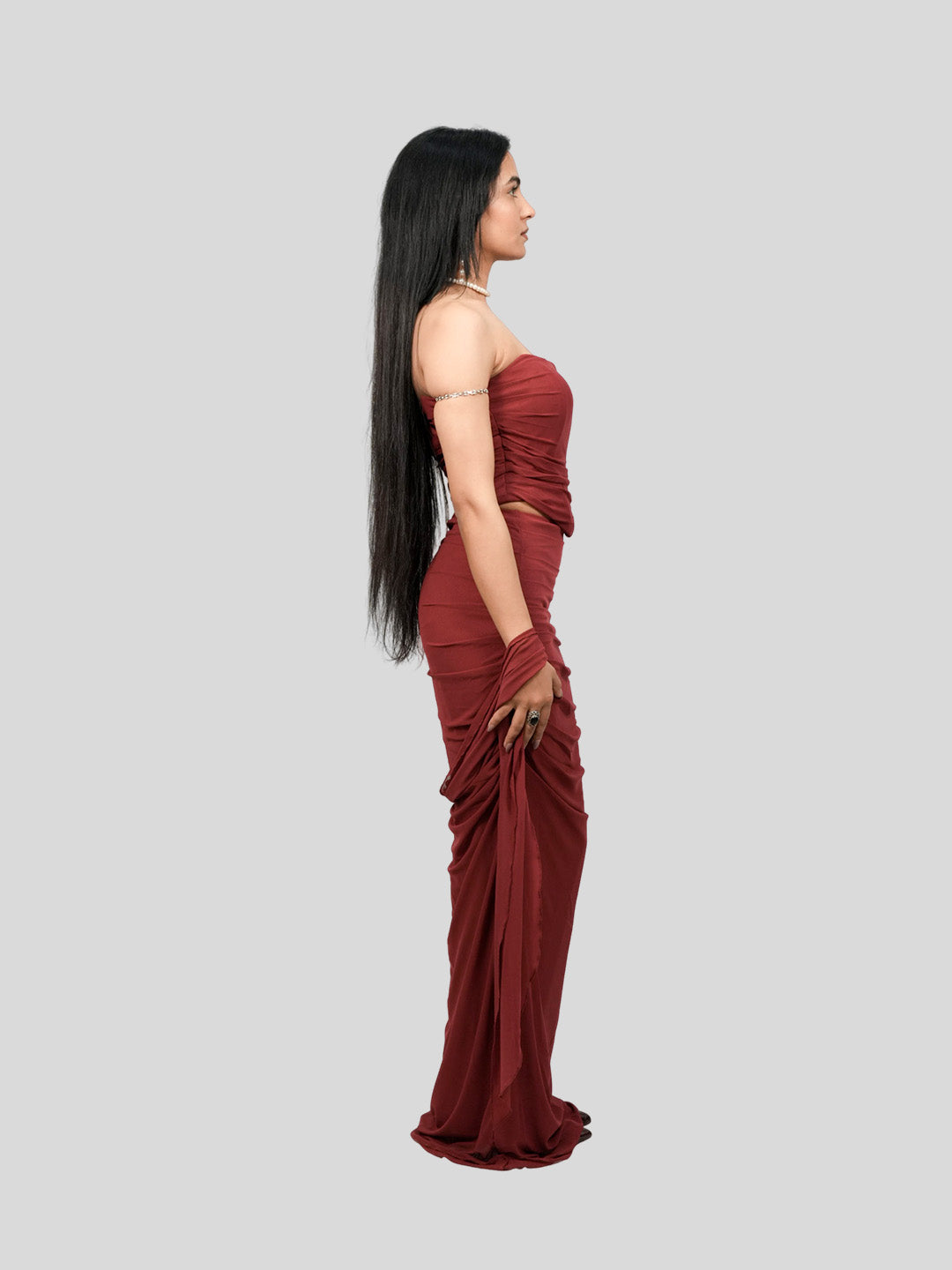 Woman wearing a burgundy strapless gown with ruched design